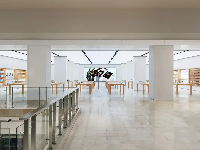 A bright store with white columns, a pale stone floor and glass balustrades
