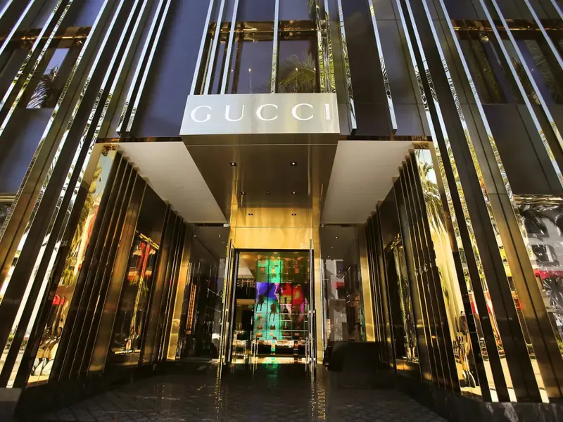 A store entrance at night framed by tall fins lit in gold