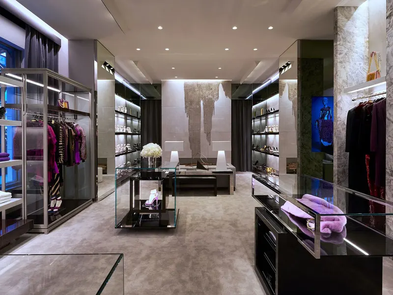 A store interior with lit wardrobes of clothing and a low display table