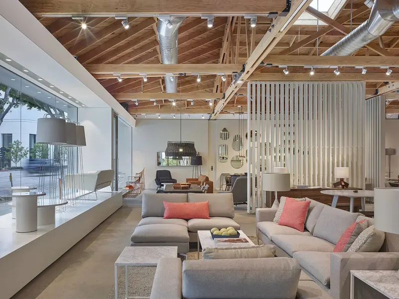 A furniture showroom with sofas under exposed timber roof trusses
