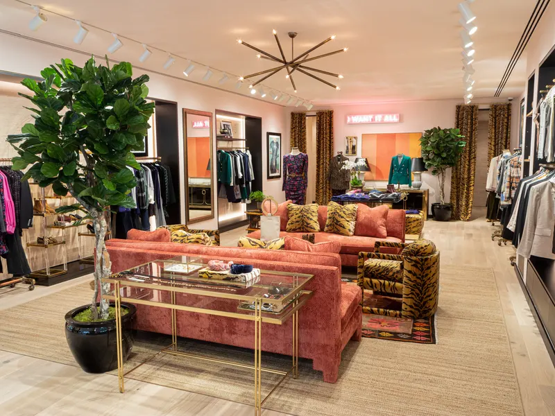 A boutique with a coral sofa, tiger-print chairs and clothing racks