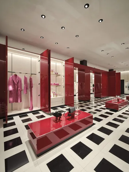 A boutique with red lacquer panels, clothing displays and a black and white floor