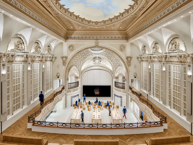 A restored theater interior with ornate plaster balconies over long display tables