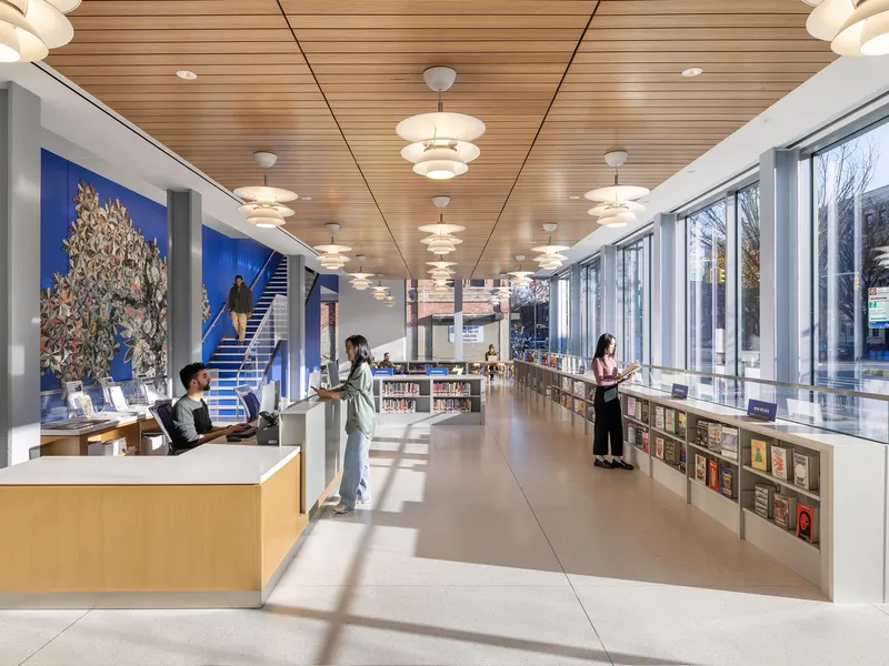 A library with a timber ceiling, a service desk and a blue wall with a mural