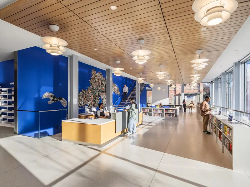 A library entrance hall with a timber ceiling, a desk and blue walls with a mural
