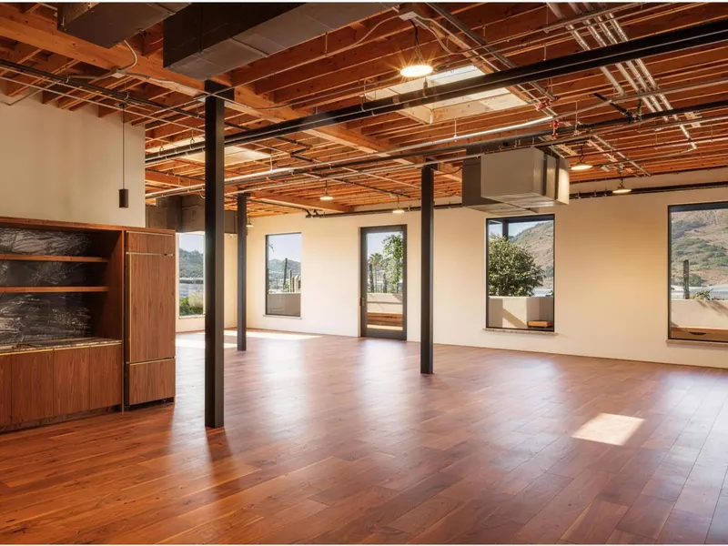 An open office with a timber floor, steel columns and an exposed timber ceiling
