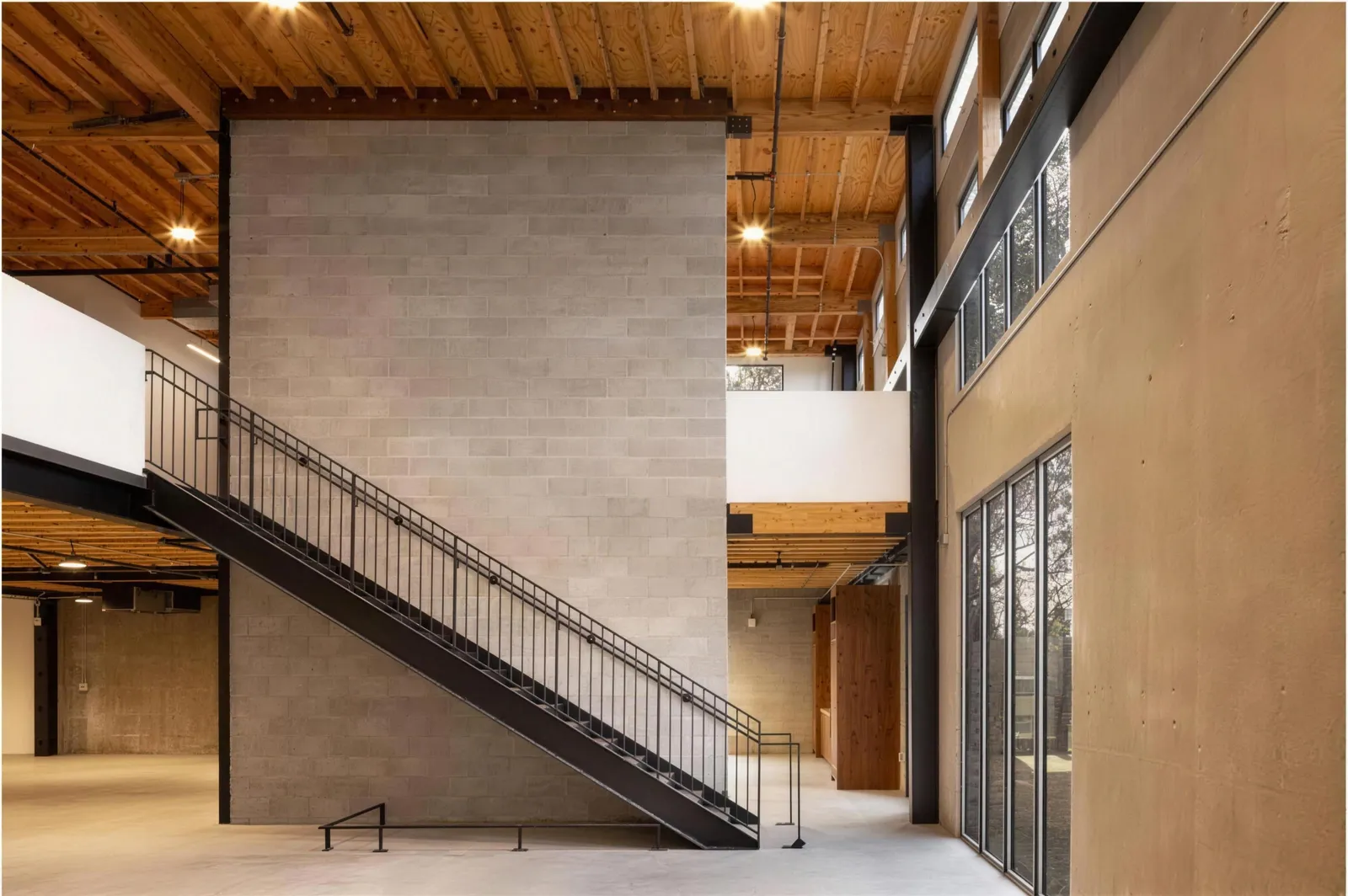 A steel stair beside a concrete wall in an office atrium