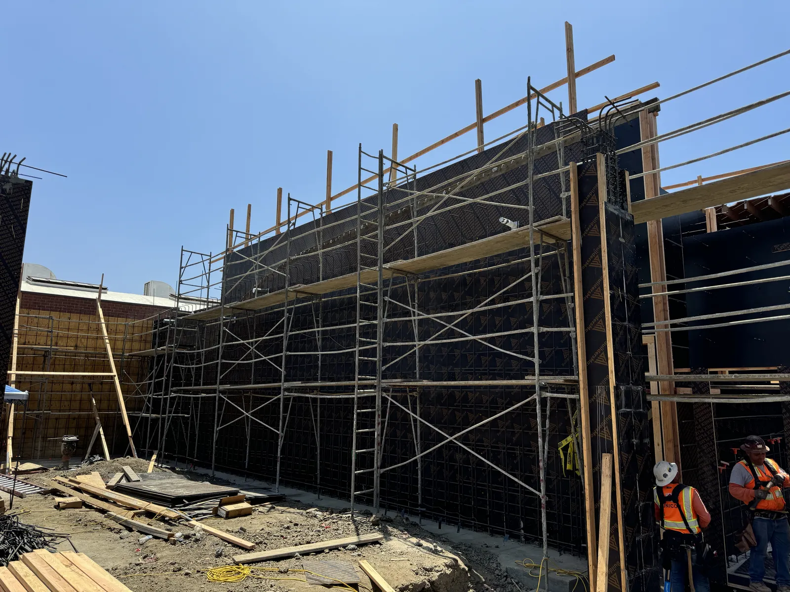 Scaffolding and wall formwork with rebar rising on a new building site