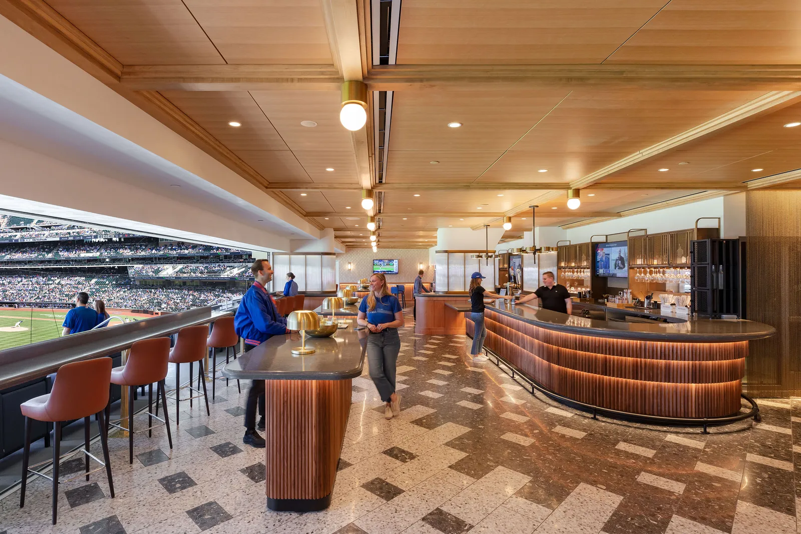 A stadium club bar with a curved counter under a timber ceiling