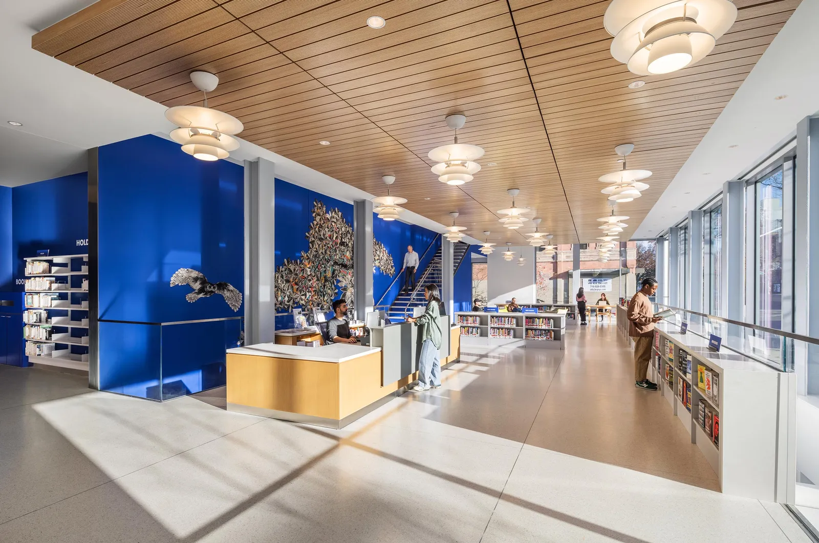A public library reading room with a timber slat ceiling
